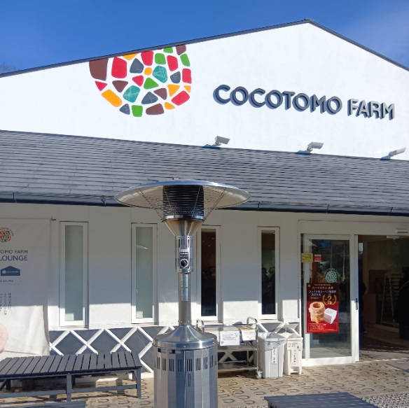 ココトモファーム犬山城三之丸店様でのパラソルヒーター利用例写真。店舗の前に設置されたベンチ付近にヒーターが設置されている。